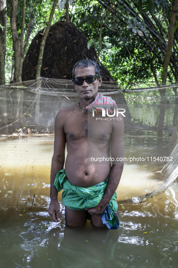 A man stands in knee-deep flood water in a village from Sonapur Union of Sonaimuri Upazila, Noakhali District, Chittagong Division, Banglade...