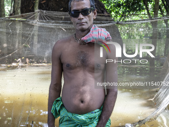 A man stands in knee-deep flood water in a village from Sonapur Union of Sonaimuri Upazila, Noakhali District, Chittagong Division, Banglade...