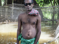 A man stands in knee-deep flood water in a village from Sonapur Union of Sonaimuri Upazila, Noakhali District, Chittagong Division, Banglade...