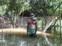 A man stands in knee-deep flood water in a village from Sonapur Union of Sonaimuri Upazila, Noakhali District, Chittagong Division, Banglade...