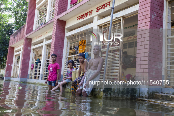 A few elderly people and children sit in front of a shelter after the floods in Sonapur Union of Sonaimuri Upazila of Noakhali District of C...