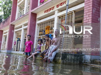 A few elderly people and children sit in front of a shelter after the floods in Sonapur Union of Sonaimuri Upazila of Noakhali District of C...