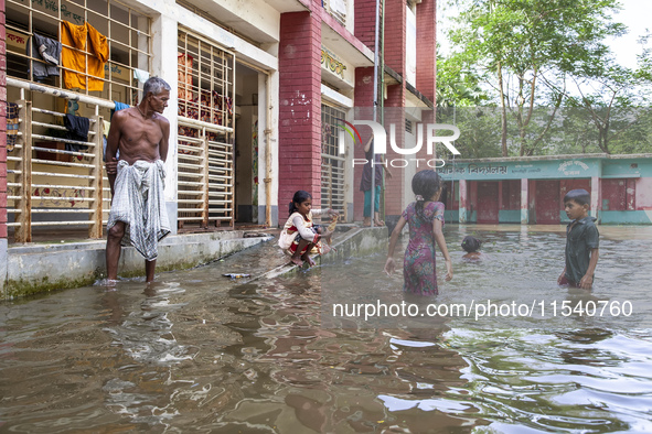 A few children bathe in flood water in front of a flood shelter in Sonapur Union of Sonaimuri Upazila of Noakhali District of Chittagong Div...