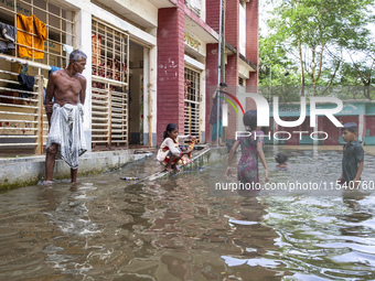 A few children bathe in flood water in front of a flood shelter in Sonapur Union of Sonaimuri Upazila of Noakhali District of Chittagong Div...