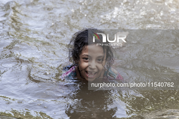 A child bathes in flood water in front of a flood shelter in Sonapur Union of Sonaimuri Upazila of Noakhali District of Chittagong Division...