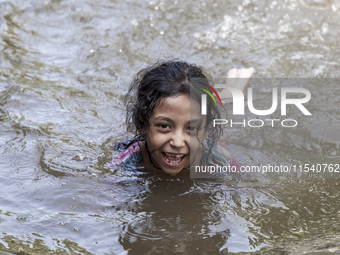 A child bathes in flood water in front of a flood shelter in Sonapur Union of Sonaimuri Upazila of Noakhali District of Chittagong Division...