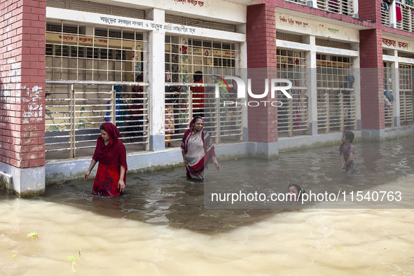 A few children bathe in flood water in front of a flood shelter in Sonapur Union of Sonaimuri Upazila of Noakhali District of Chittagong Div...