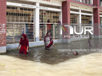 A few children bathe in flood water in front of a flood shelter in Sonapur Union of Sonaimuri Upazila of Noakhali District of Chittagong Div...