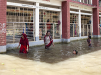 A few children bathe in flood water in front of a flood shelter in Sonapur Union of Sonaimuri Upazila of Noakhali District of Chittagong Div...