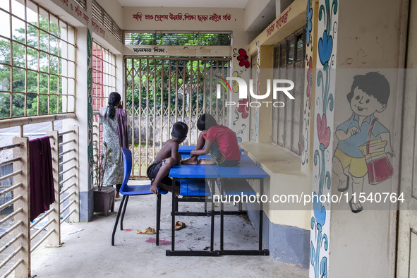 A few children play ludo sitting on tables and chairs on the balcony in a flood shelter in Sonapur Union of Sonaimuri Upazila, Noakhali Dist...