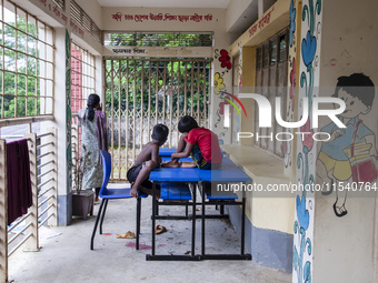 A few children play ludo sitting on tables and chairs on the balcony in a flood shelter in Sonapur Union of Sonaimuri Upazila, Noakhali Dist...