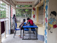 A few children play ludo sitting on tables and chairs on the balcony in a flood shelter in Sonapur Union of Sonaimuri Upazila, Noakhali Dist...