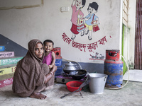 A woman cooks rice with a gas stove at a flood shelter in Sonapur Union, Sonaimuri Upazila, Noakhali District, Chittagong Division, Banglade...