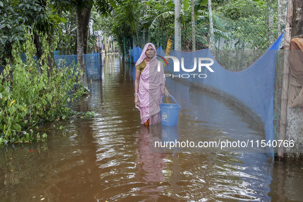 An elderly woman stands in knee-deep flood water in Sonapur Union of Sonaimuri Upazila of Noakhali District of Chittagong Division in Noakha...