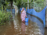 An elderly woman stands in knee-deep flood water in Sonapur Union of Sonaimuri Upazila of Noakhali District of Chittagong Division in Noakha...