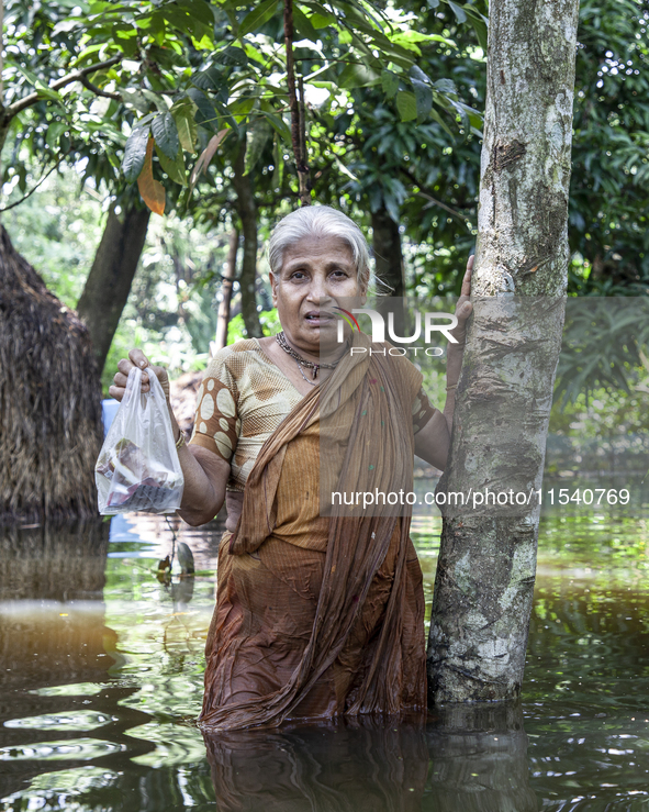 An elderly woman stands in waist-deep flood water in a village of Sonapur Union in Sonaimuri Upazila of Noakhali District of Chittagong Divi...