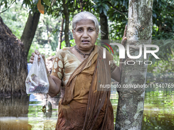 An elderly woman stands in waist-deep flood water in a village of Sonapur Union in Sonaimuri Upazila of Noakhali District of Chittagong Divi...