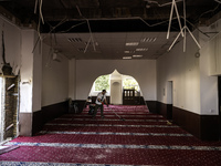 Believers and volunteers clean up the building of the Islamic Cultural Center and Mosque, which is damaged after the Russian missile attacks...