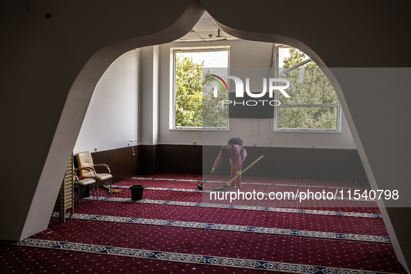 Believers and volunteers clean up the building of the Islamic Cultural Center and Mosque, which is damaged after the Russian missile attacks...