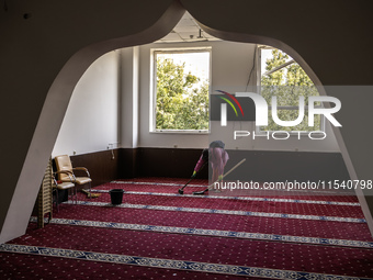 Believers and volunteers clean up the building of the Islamic Cultural Center and Mosque, which is damaged after the Russian missile attacks...