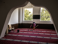 Believers and volunteers clean up the building of the Islamic Cultural Center and Mosque, which is damaged after the Russian missile attacks...