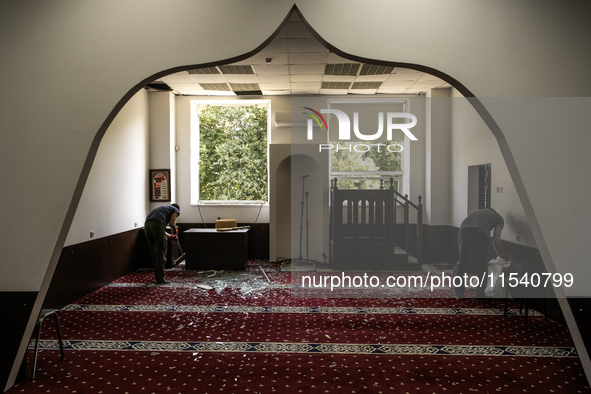 Believers and volunteers clean up the building of the Islamic Cultural Center and Mosque, which is damaged after the Russian missile attacks...