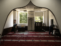 Believers and volunteers clean up the building of the Islamic Cultural Center and Mosque, which is damaged after the Russian missile attacks...