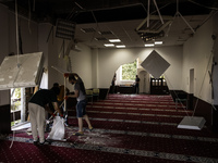 Believers and volunteers clean up the building of the Islamic Cultural Center and Mosque, which is damaged after the Russian missile attacks...