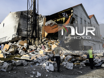 Experts work near the sports complex of a university on a heavily damaged and partially collapsed building after the Russian missile attacks...