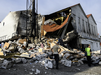 Experts work near the sports complex of a university on a heavily damaged and partially collapsed building after the Russian missile attacks...