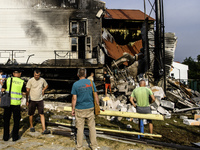 People stand near the sports complex of a university, a heavily damaged and partially collapsed building, after the Russian missile attacks...