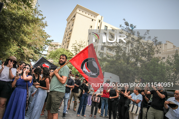 A young man holds an Anti Fascist Action flag during a demonstration staged by human rights activists, women's rights organizations, and civ...