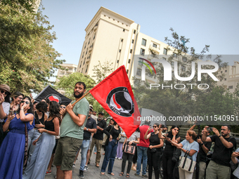 A young man holds an Anti Fascist Action flag during a demonstration staged by human rights activists, women's rights organizations, and civ...