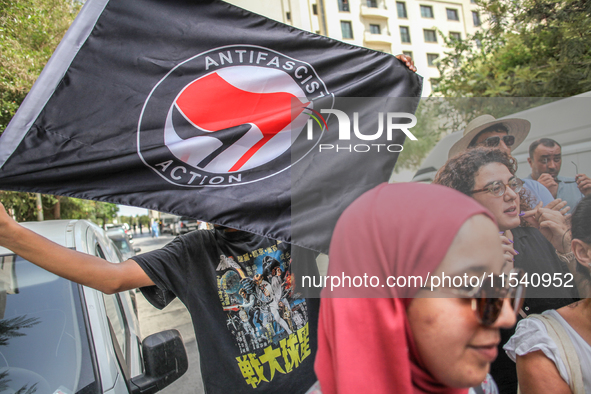 A young man holds an Anti Fascist Action flag during a demonstration staged by human rights activists, women's rights organizations, and civ...