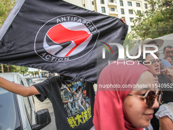 A young man holds an Anti Fascist Action flag during a demonstration staged by human rights activists, women's rights organizations, and civ...