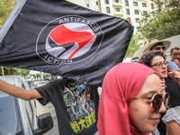 A young man holds an Anti Fascist Action flag during a demonstration staged by human rights activists, women's rights organizations, and civ...