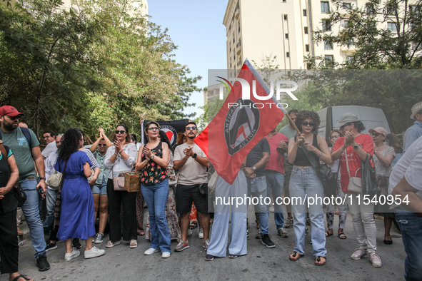 A young female demonstrator waves an Anti-Fascist Action flag as others shout slogans during a demonstration staged by human rights activist...