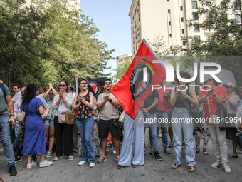 A young female demonstrator waves an Anti-Fascist Action flag as others shout slogans during a demonstration staged by human rights activist...