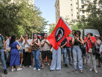 A young female demonstrator waves an Anti-Fascist Action flag as others shout slogans during a demonstration staged by human rights activist...