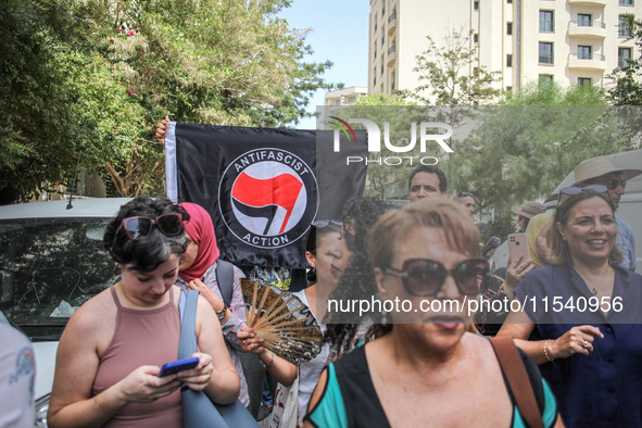 A young man raises an Anti Fascist Action flag during a demonstration staged by human rights activists, women's rights organizations, and ci...