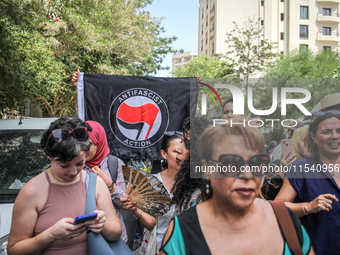 A young man raises an Anti Fascist Action flag during a demonstration staged by human rights activists, women's rights organizations, and ci...