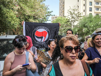 A young man raises an Anti Fascist Action flag during a demonstration staged by human rights activists, women's rights organizations, and ci...