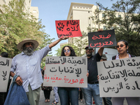 A young female demonstrator holds a placard that reads in Arabic, ''The non-independent High Authority for Elections, fake elections of Kais...