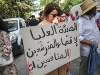 A female demonstrator holds a placard that reads in Arabic, ''the High Authority For eliminating the competing candidates,'' during a demons...