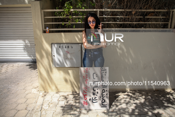 A young demonstrator smokes a cigarette next to a placard that reads in Arabic, ''the non-independent High Authority for Elections, fake ele...