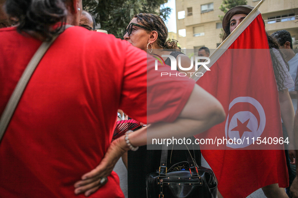 A female demonstrator holds the Tunisian national flag as she attends a demonstration staged by human rights activists, women's rights organ...