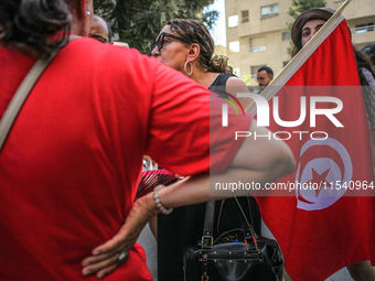 A female demonstrator holds the Tunisian national flag as she attends a demonstration staged by human rights activists, women's rights organ...