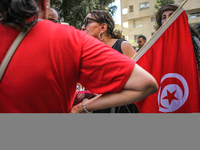 A female demonstrator holds the Tunisian national flag as she attends a demonstration staged by human rights activists, women's rights organ...