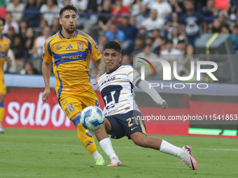 Piero Quispe #27 of Pumas slides to the ball against Fernando Gorriaran #8 of Tigres during Matchday 6 as part of the Torneo de Apertura 202...