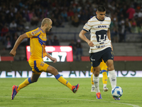 Guillermo Martinez Ayala #9 of Pumas drives the ball against Guido Pizarro #19 of Tigres during Matchday 6 as part of the Torneo de Apertura...